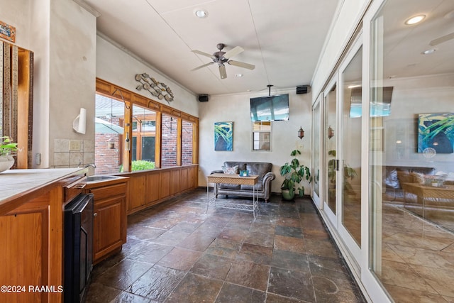 sunroom featuring ceiling fan and sink