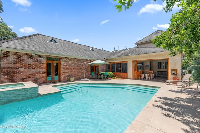 view of pool featuring a bar, an in ground hot tub, and a patio