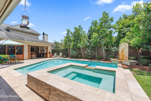 view of pool featuring a patio area, an outdoor bar, and an in ground hot tub