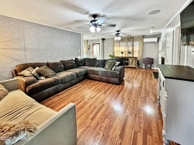 living room featuring ornamental molding, a wall mounted air conditioner, and light hardwood / wood-style flooring