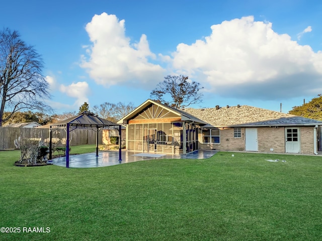 back of house with a gazebo, a yard, a sunroom, and a patio