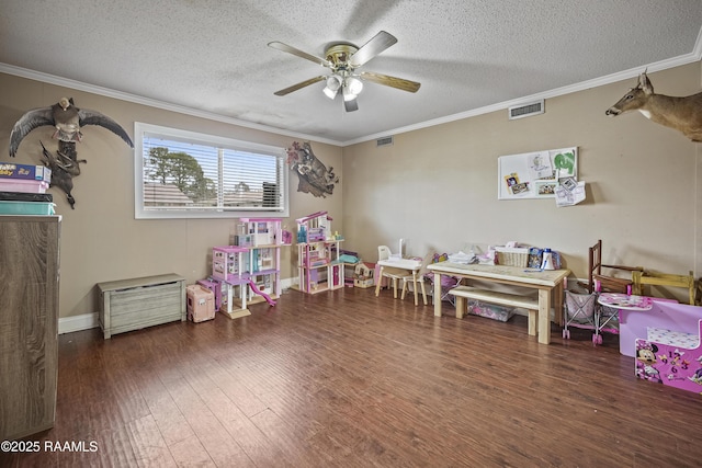 playroom with ceiling fan, crown molding, dark hardwood / wood-style floors, and a textured ceiling