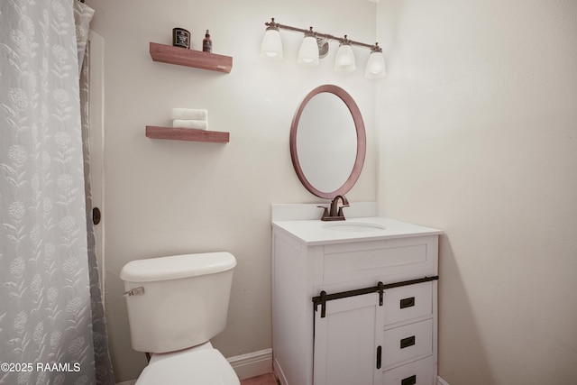 bathroom featuring vanity, curtained shower, and toilet