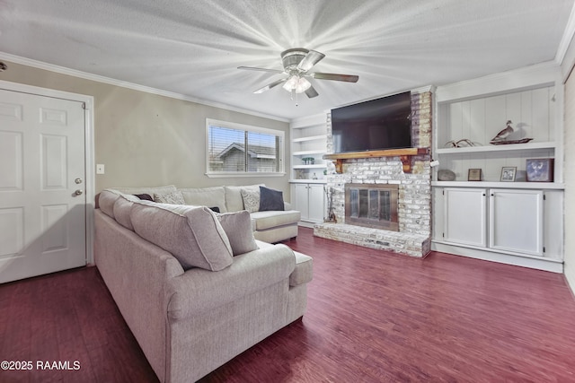 living room featuring crown molding, a brick fireplace, built in features, and dark hardwood / wood-style flooring