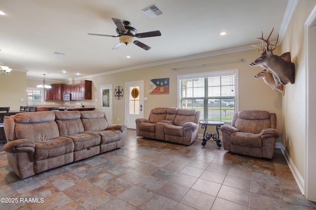 living room featuring crown molding and ceiling fan with notable chandelier