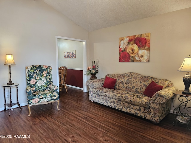 living room with lofted ceiling, a textured ceiling, baseboards, and wood finished floors