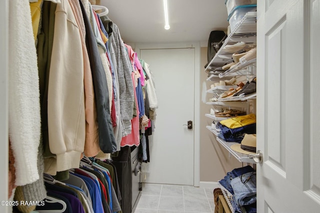 walk in closet with light tile patterned floors