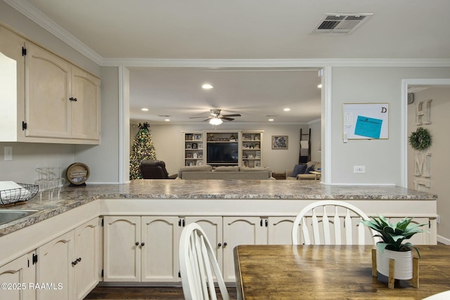 kitchen with cream cabinetry, crown molding, kitchen peninsula, and ceiling fan