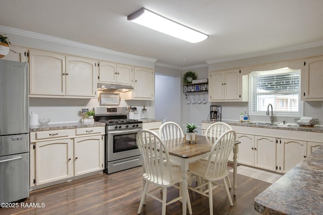 kitchen featuring sink, dark wood-type flooring, stainless steel appliances, ornamental molding, and cream cabinetry