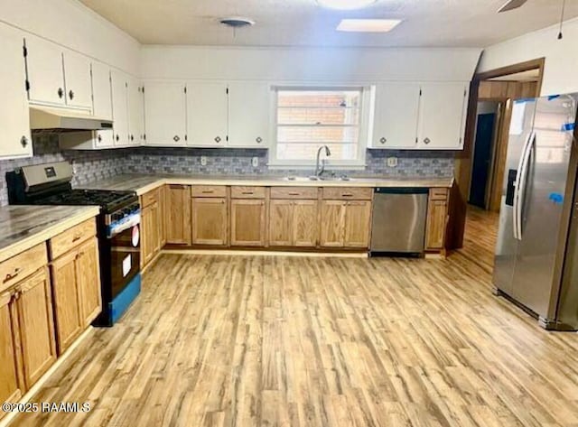 kitchen with white cabinetry, sink, light hardwood / wood-style floors, and appliances with stainless steel finishes