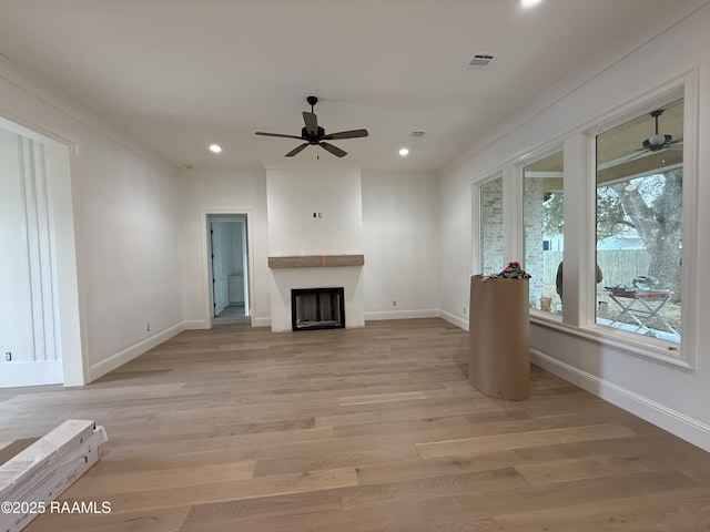 unfurnished living room featuring light hardwood / wood-style flooring, ornamental molding, and ceiling fan