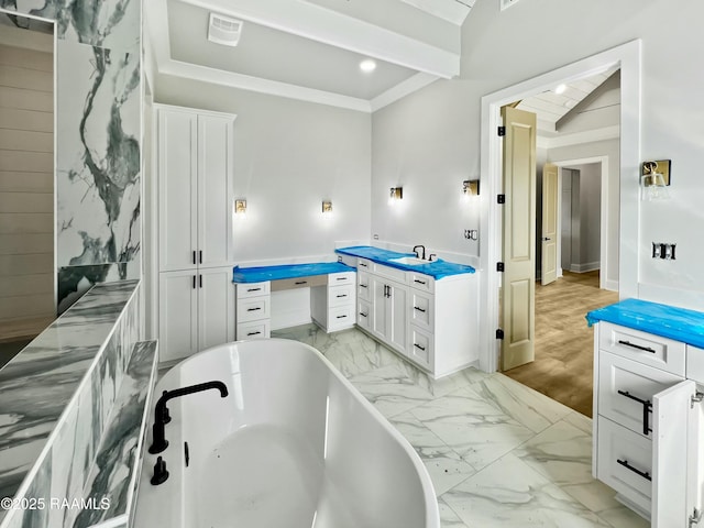 bathroom with crown molding, vanity, and a bathtub