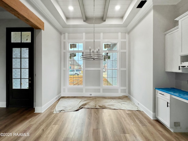 unfurnished dining area featuring beamed ceiling, a chandelier, and light hardwood / wood-style floors