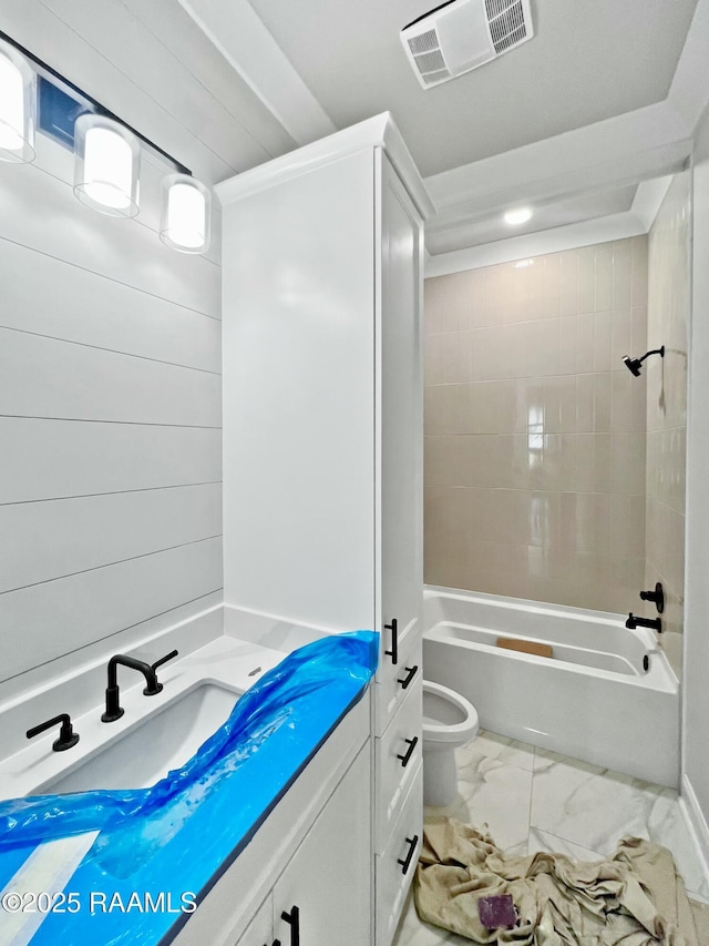 full bathroom featuring tiled shower / bath, vanity, and toilet