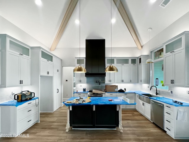 kitchen with a kitchen island, appliances with stainless steel finishes, decorative light fixtures, sink, and a kitchen breakfast bar