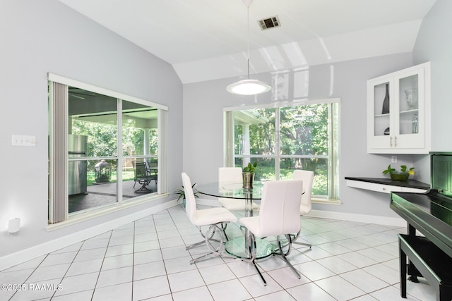 dining area with light tile patterned floors and vaulted ceiling