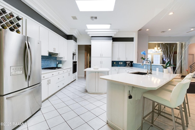 kitchen featuring white cabinetry, sink, a breakfast bar area, oven, and stainless steel fridge with ice dispenser