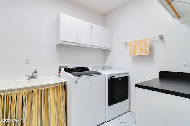 washroom with cabinets, light tile patterned floors, and washing machine and clothes dryer