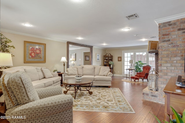 living room with wood-type flooring and ornamental molding