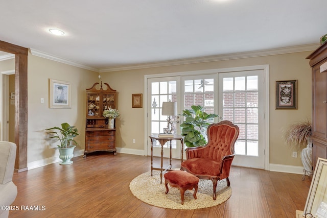 living area featuring crown molding and light wood-type flooring