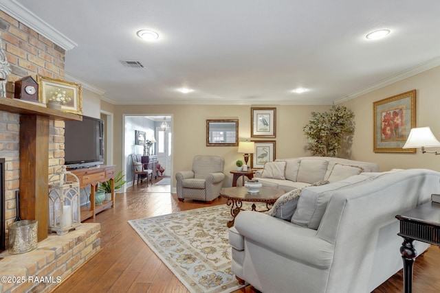 living room with ornamental molding, a fireplace, and light hardwood / wood-style floors