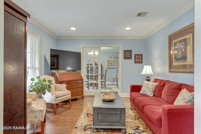 living room featuring ornamental molding and light wood-type flooring