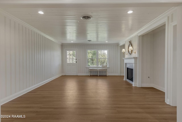 unfurnished living room featuring hardwood / wood-style flooring and crown molding