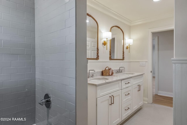 bathroom with tiled shower, ornamental molding, and vanity