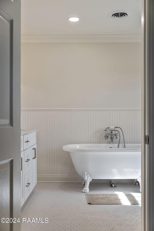 bathroom with a tub to relax in, ornamental molding, and vanity