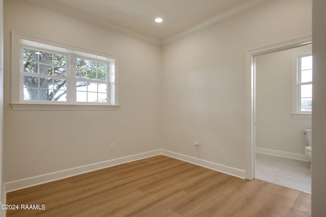 spare room with ornamental molding and light hardwood / wood-style floors