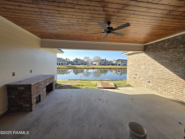 view of patio with a water view, ceiling fan, and exterior fireplace