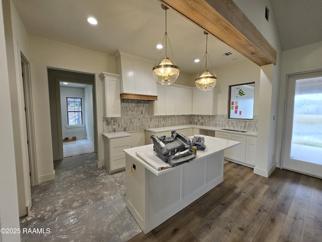 kitchen featuring decorative light fixtures, a center island, white cabinets, and decorative backsplash