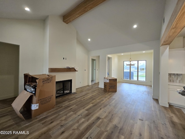 living room with dark hardwood / wood-style flooring, high vaulted ceiling, a chandelier, and beam ceiling