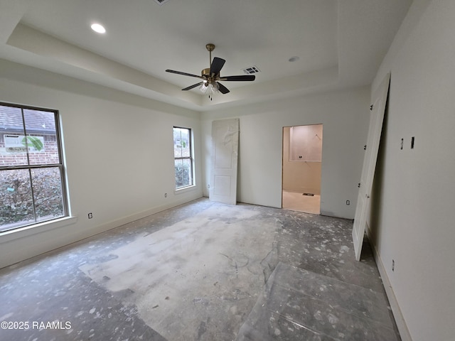 unfurnished bedroom with ensuite bathroom and a raised ceiling