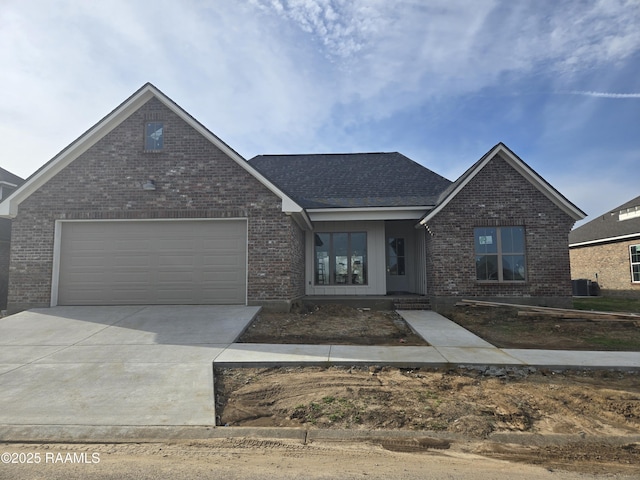 view of front of house featuring cooling unit, concrete driveway, and brick siding