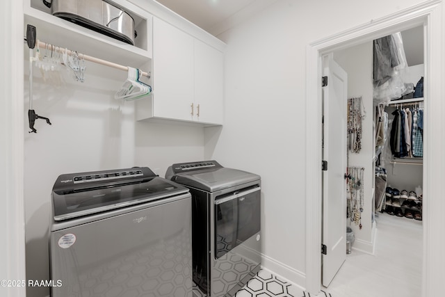 laundry room with independent washer and dryer and cabinets