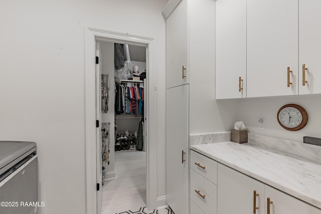 interior space with light stone countertops and white cabinets