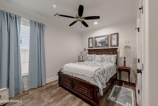 bedroom with ceiling fan, ornamental molding, and light wood-type flooring