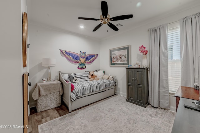 bedroom featuring ornamental molding, ceiling fan, and light wood-type flooring