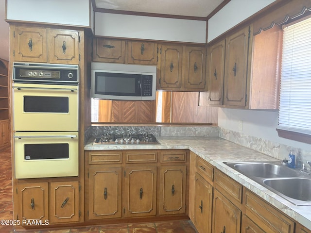 kitchen featuring ornamental molding, appliances with stainless steel finishes, and sink