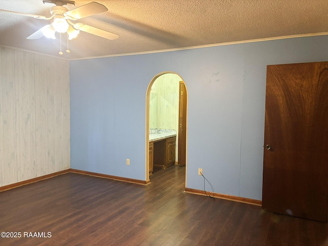 spare room featuring crown molding, ceiling fan, dark hardwood / wood-style floors, and a textured ceiling