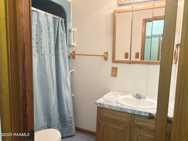 bathroom with vanity, curtained shower, and toilet