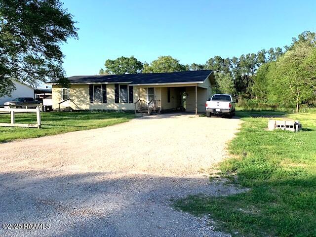 ranch-style house featuring a carport and a front yard