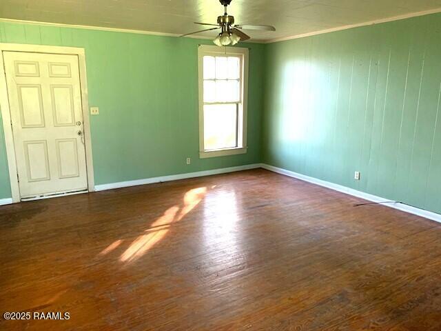 empty room with ceiling fan, ornamental molding, and dark hardwood / wood-style flooring