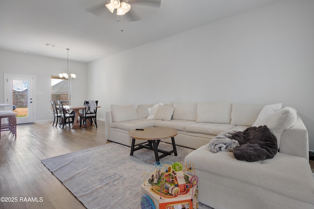 living room featuring hardwood / wood-style floors and ceiling fan with notable chandelier