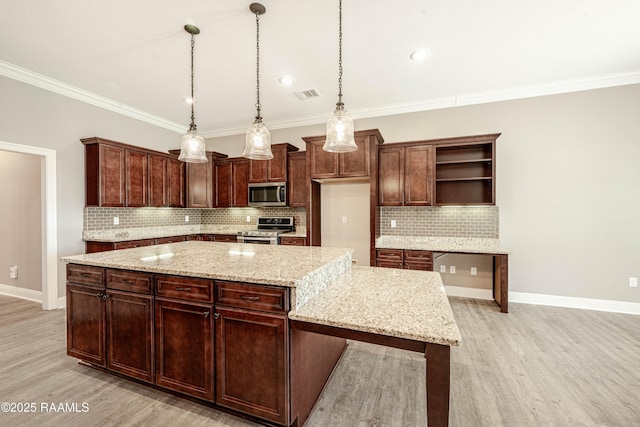 kitchen featuring decorative light fixtures, a center island, stainless steel appliances, light stone countertops, and light hardwood / wood-style floors