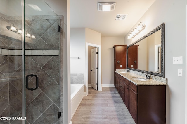 bathroom with vanity, independent shower and bath, and wood-type flooring