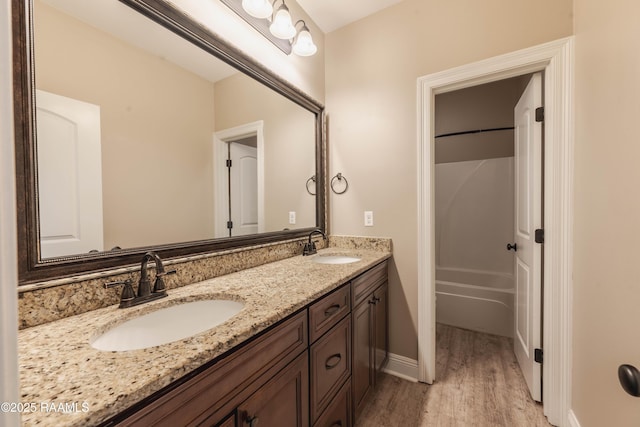 bathroom with hardwood / wood-style flooring, shower / bathtub combination, and vanity