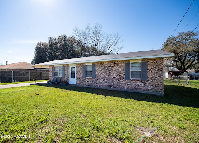 single story home with fence, a front lawn, and brick siding