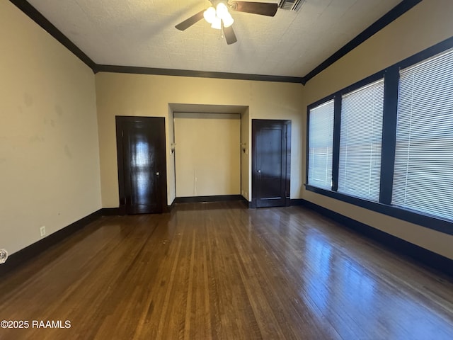 spare room featuring crown molding, dark hardwood / wood-style floors, elevator, and ceiling fan